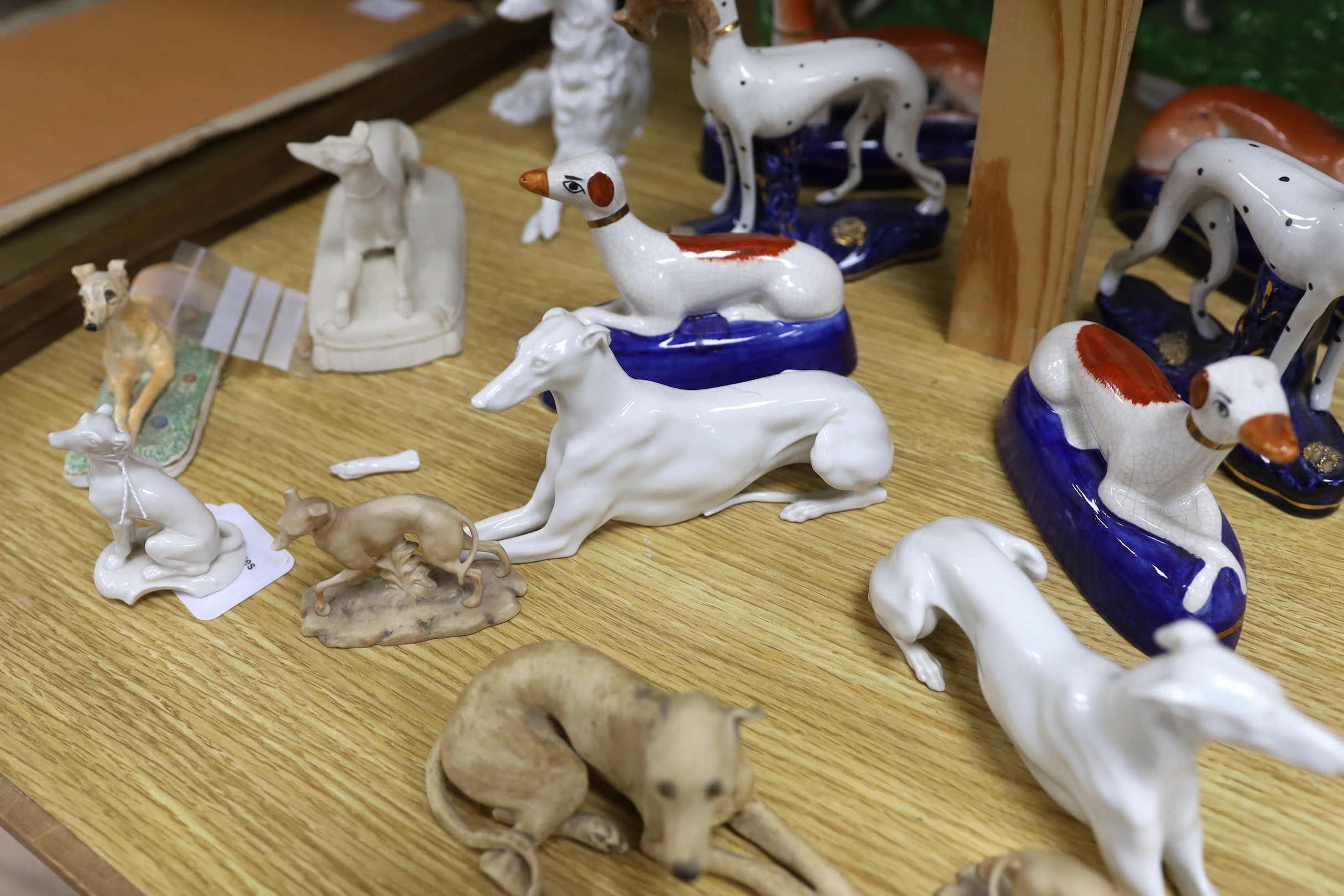 A collection of four pairs of Staffordshire dogs, together with nine other models of reclining hounds, tallest 25cm